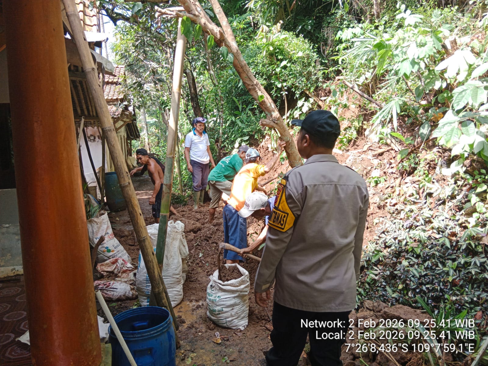 Gotong Royong, Bhabinkamtibmas Polsek Cilongok Polresta Banyumas Evakuasi Material Longsor di Halaman Rumah Warga
